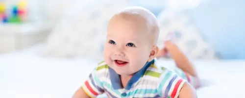 Tijdens tummy-time druk een baby van 14 weken oud zich bewust op.