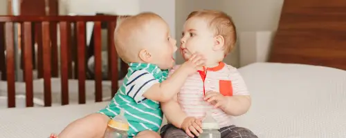 2 baby's van 20 weken oud spelen samen en maken geluidjes naar elkaar.