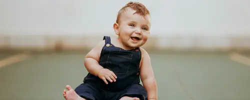 Baby van 21 weken oud kan al even zitten en steunt zichzelf met 1 handje