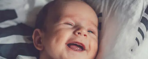 Een baby lacht wanneer ze haar moeder ziet