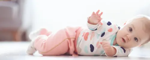 Baby van 16 weken oud probeert zichzelf om te rollen op de grond