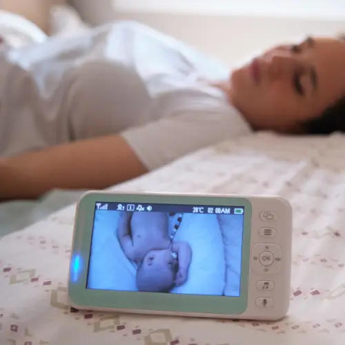 Vrouw ligt te slapen op bed naast een babyfoon
