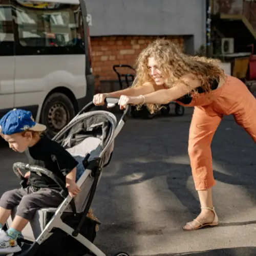 Lange vrouw duwt haar kinderwagen vooruit