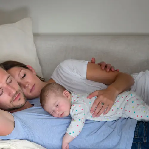 Baby ligt veilig op zijn buik op het lichaam van zijn ouders.